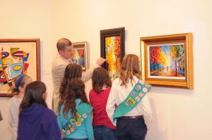Girl Scouts learn about palette knife technique by studying a painting by Slava Ilyayev