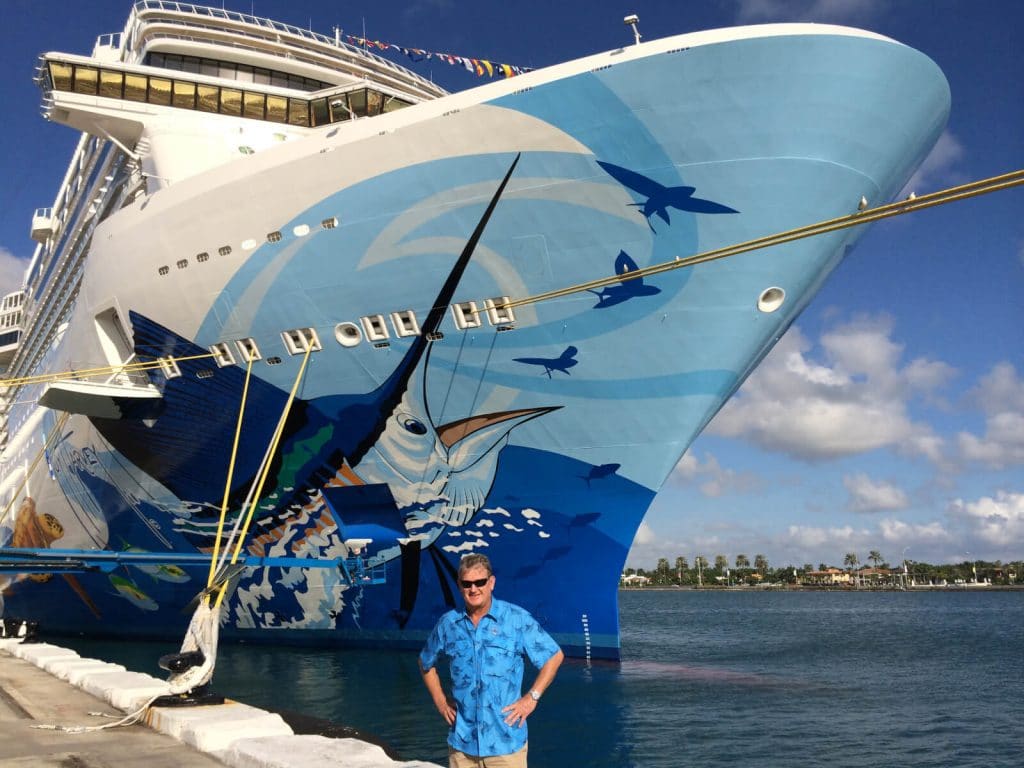 Guy Harvey standing in front of his largest commission yet, the Norwegian Escape