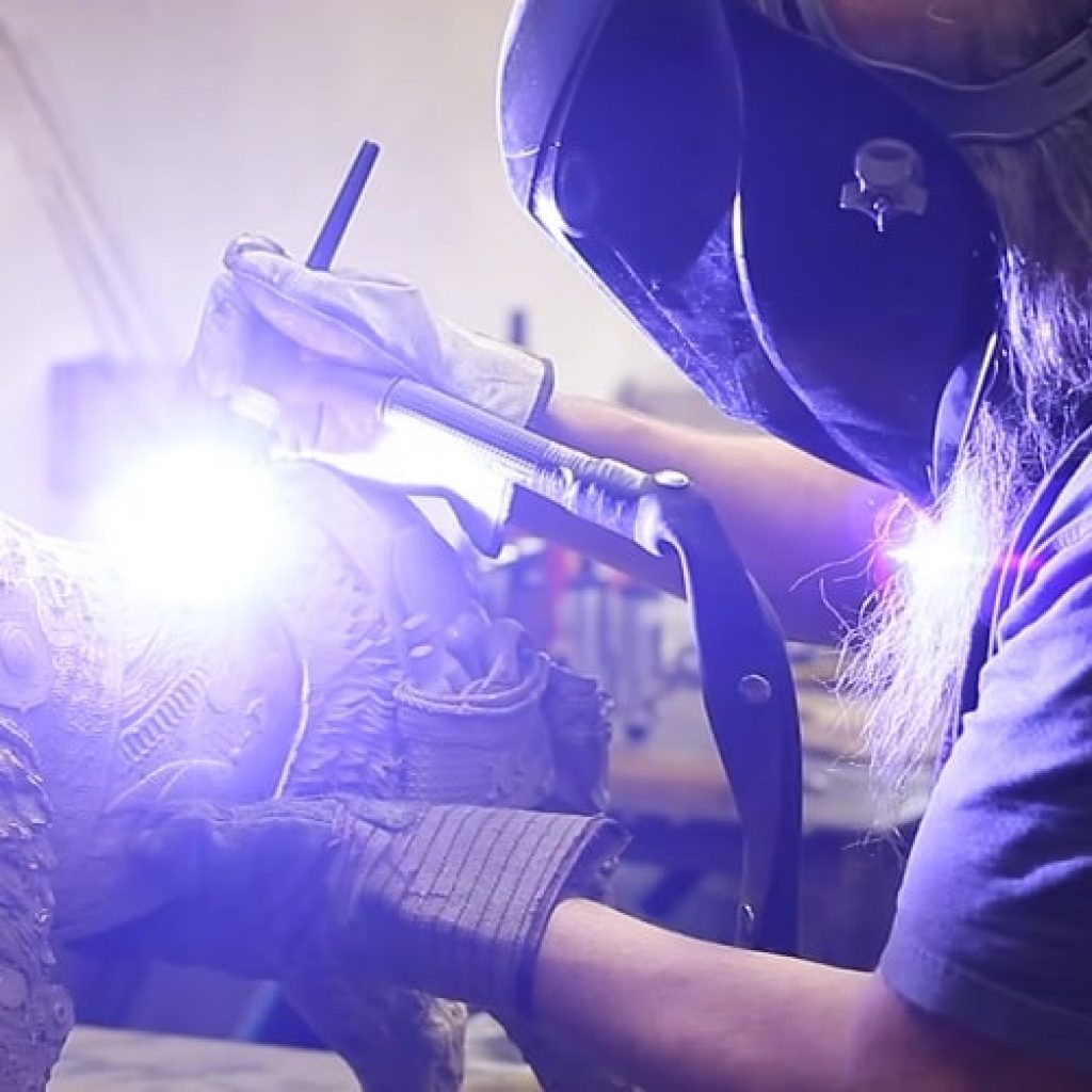 Lopez welds together the bronze pieces of one of his sculptures.