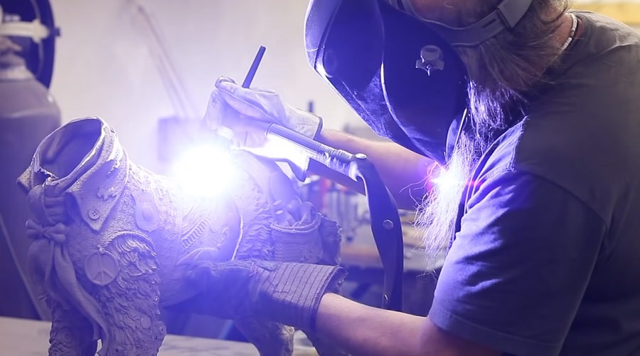 Lopez welds together the bronze pieces of one of his sculptures.