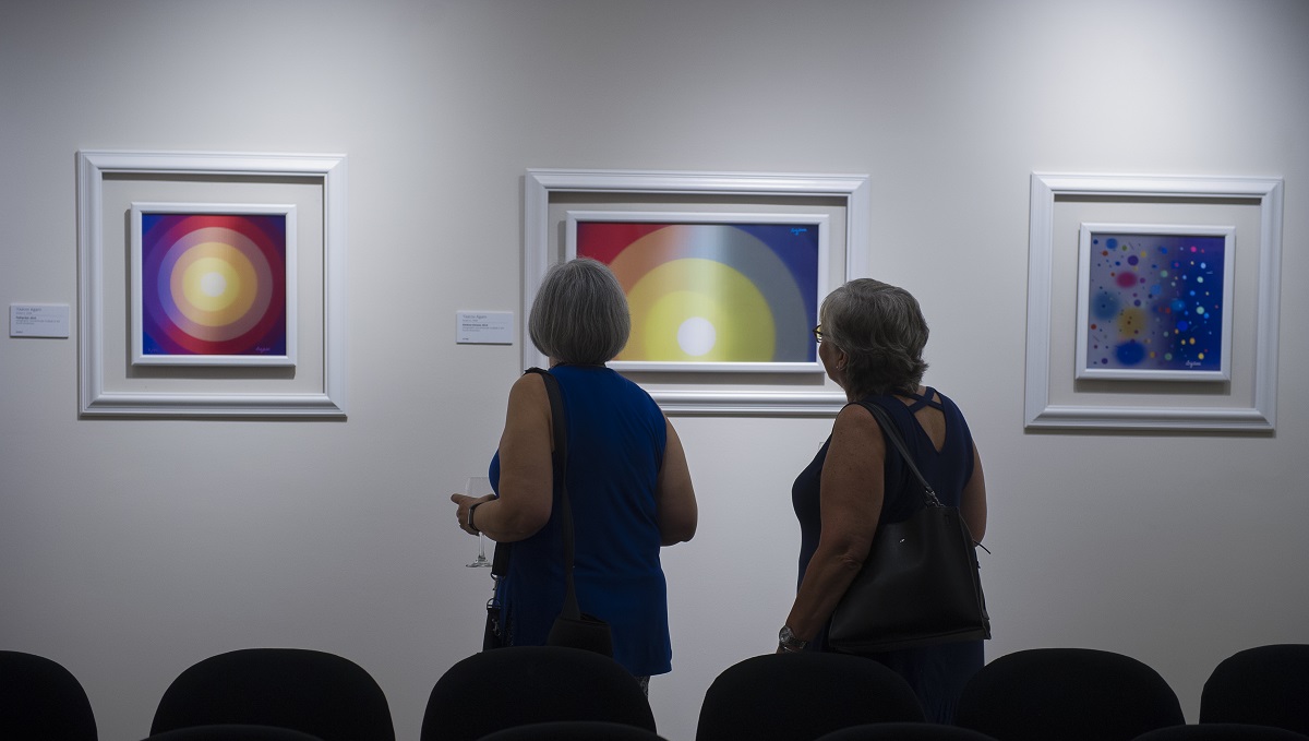 Guests observe artwork by Yaacov Agam at Park West Gallery.