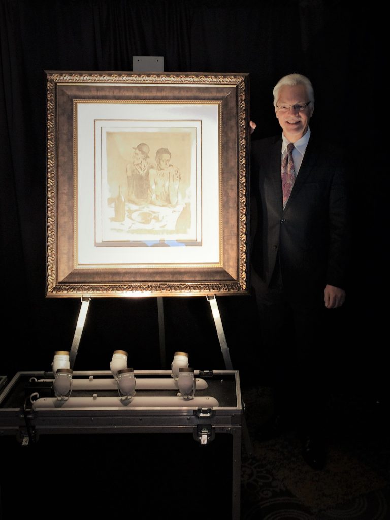 Art Gallery Director stands with a large framed picasso etching