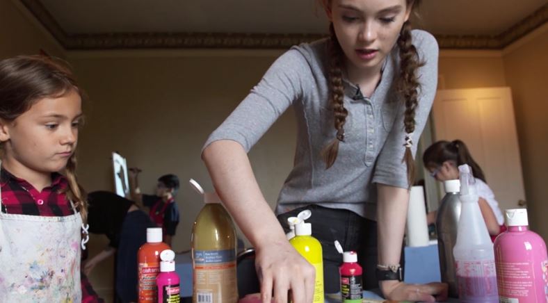 Autumn de Forest paints with young students in a classroom