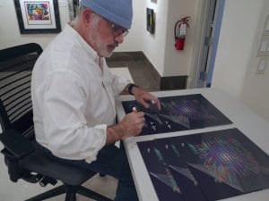 Ron Agam signs editions of his "New York" 3-DK art.