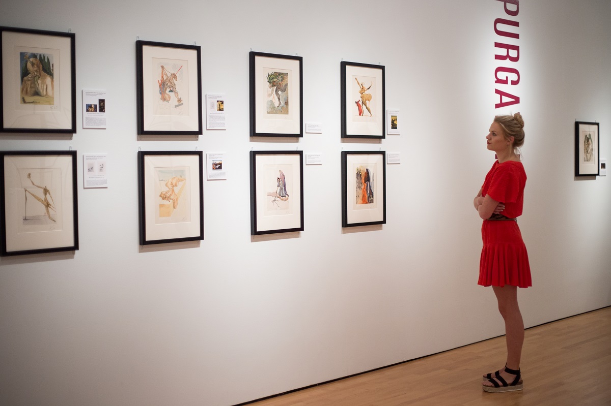 A guest takes in Dalí’s take on Dante's "Divine Comedy" at the Hilliard Art Museum's opening for “Salvador Dalí’s Stairway to Heaven.”