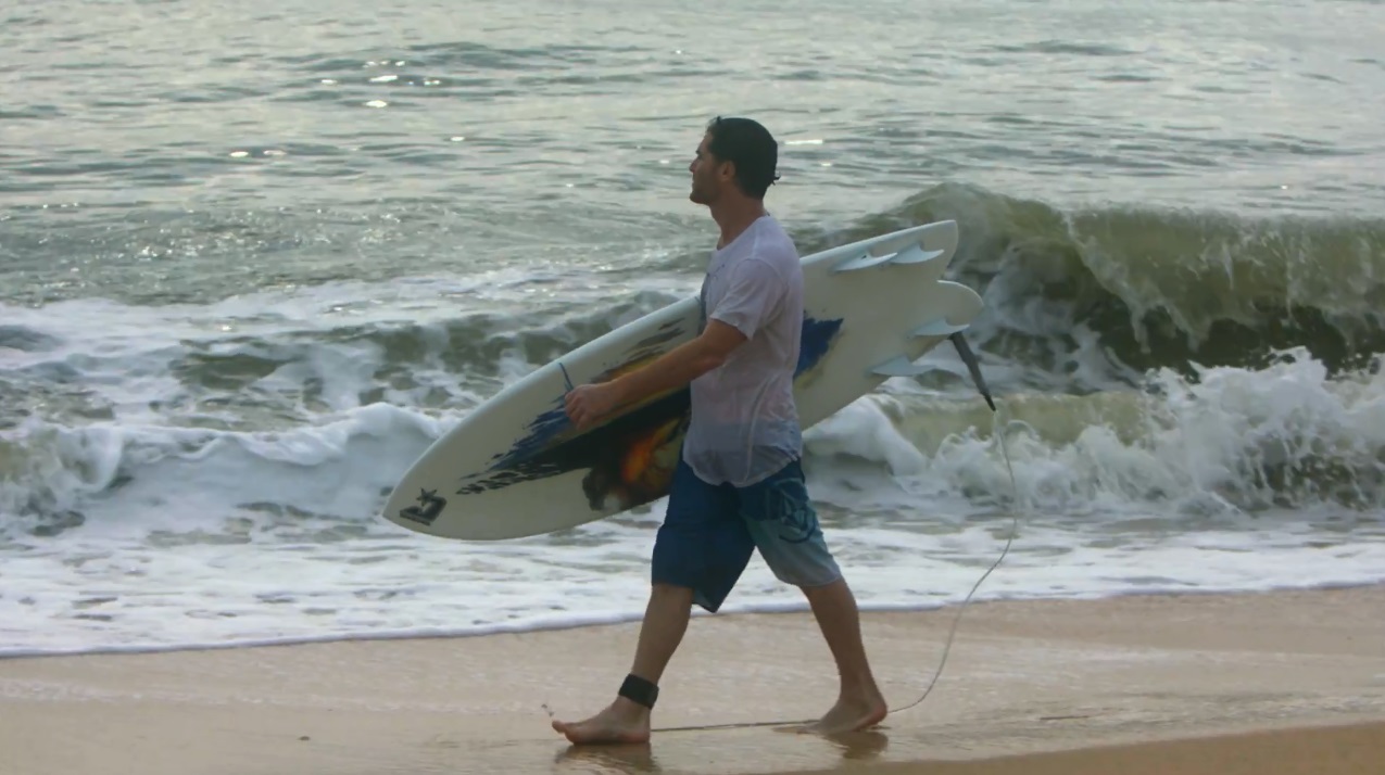 Artist Matt Beyrer walks in the surf.