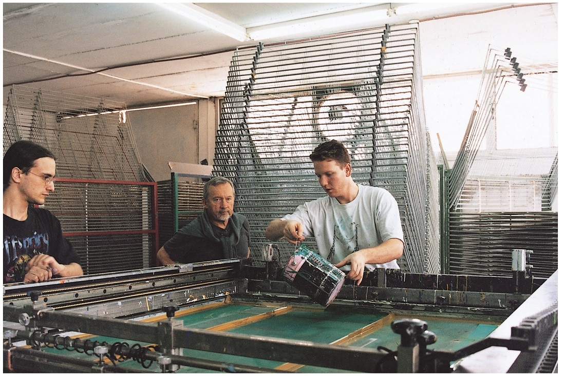 Medvedev watches as artisans spread color over the silkscreen during the serigraphy process