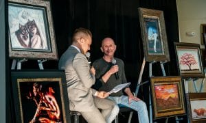 Craig Tracy talks in front of an audience at Park West Gallery in Miami.