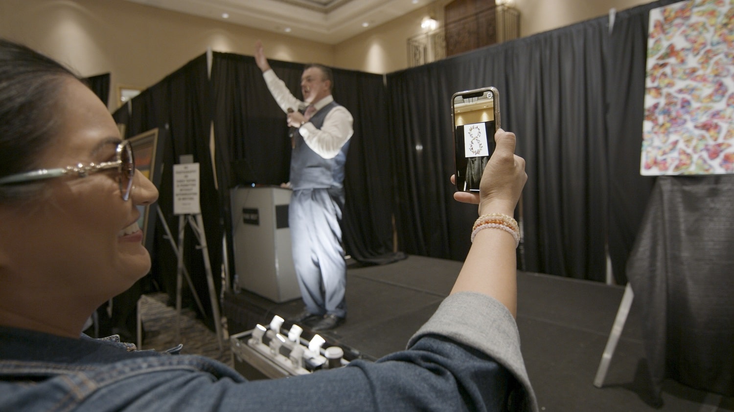 A collector watches as the butterflies on Yanke's new augmented reality art form an infinity symbol.