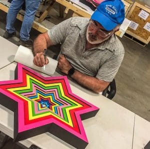 Ron Agam signs a new edition of his "Star of David" sculptograph. (Credit: Instagram)
