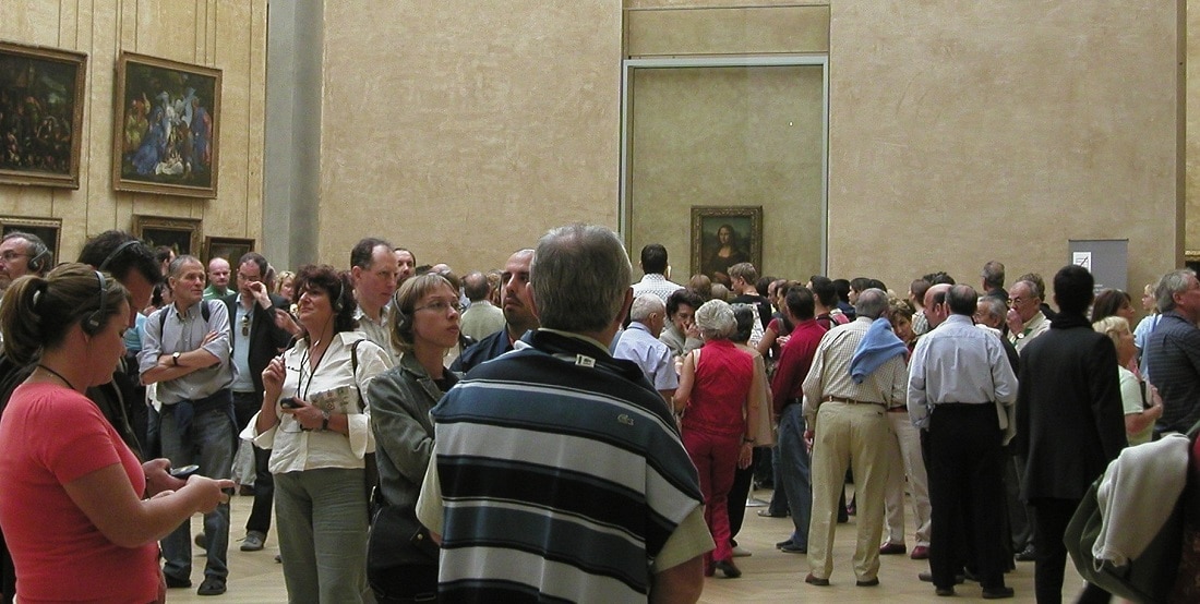 Crowds navigate the "Mona Lisa" gallery at the Louvre