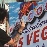 Michael Godard paints one of his olives (and a tribute to his hometown) in Las Vegas' Neon Museum.