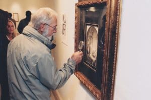 An art lover closely inspects one of Rembrandt's Millennium etchings at Park West Museum.