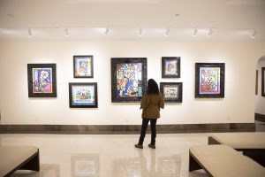 A visitor browses a wall of works by artist Romero Britto in Park West Museum's downstairs gallery space.