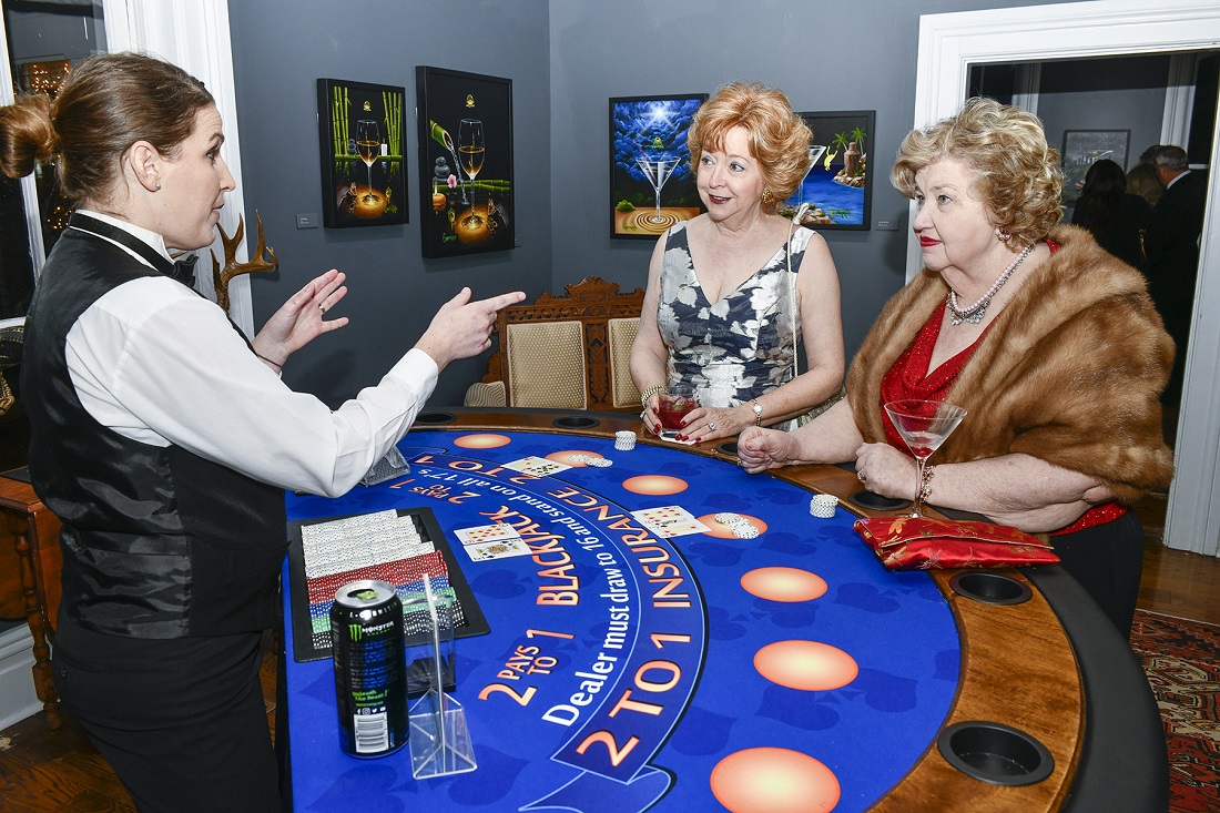 Two Monthaven patrons place their bets while surrounded by Michael Godard's artwork.