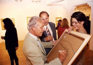 Picot signing a painting for an excited fan at the opening of a 2010 Park West exhibition.