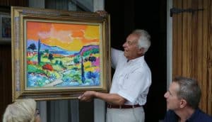 Jean-Claude Picot proudly shows one of his paintings at his home in France.