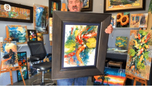 James Coleman shows a large framed painting to the camera