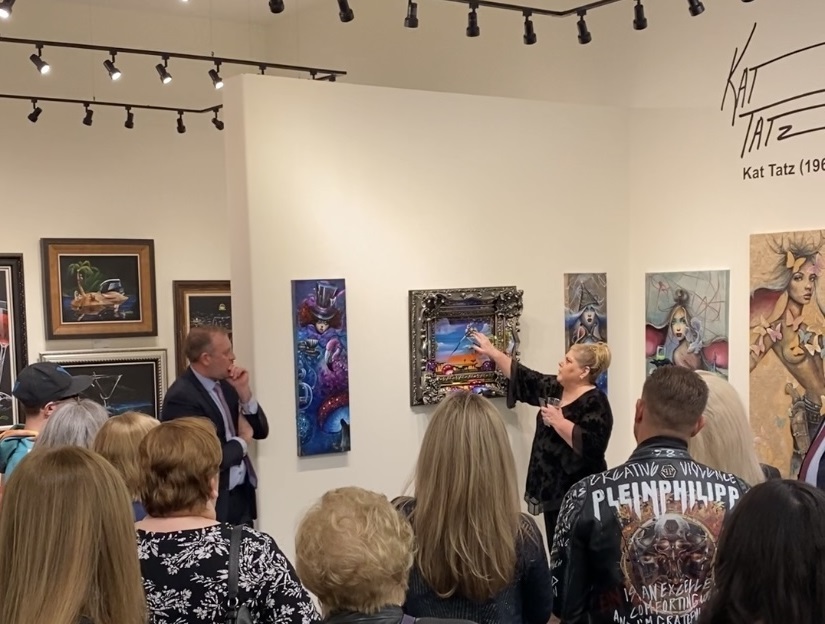Kat talks about one of her paintings with Park West Vegas Director Michael Vergis in front of a crowd of collectors