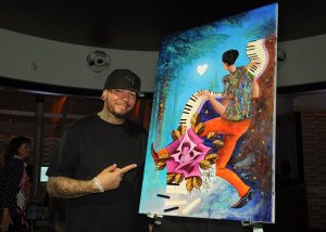 Miami art superstar Kre8 poses with “Love in Triple Time”