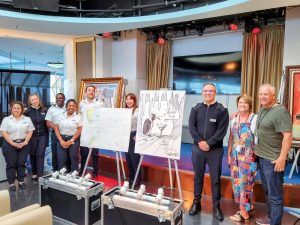 The Celebrity Infinity crew poses with Michael Godard's live drawing and the collectors who purchased it